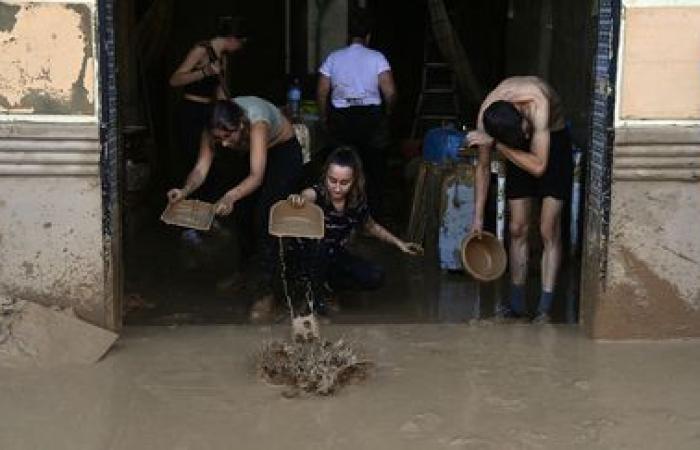 una folla di volontari è impegnata a ripulire le città colpite dal disastro vicino a Valencia