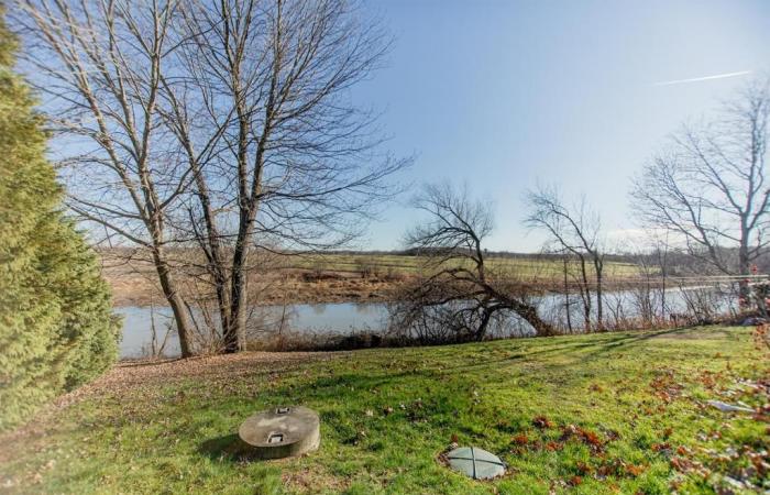 Elegante cottage confinante con uno specchio d’acqua in uno sfondo di tranquillità rurale