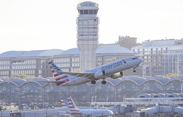 Un passeggero tenta di aprire la porta di un aereo durante il volo, gli altri passeggeri lo fissano con del nastro adesivo