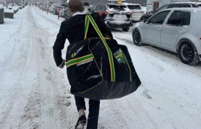 Il giocatore selvaggio deve percorrere tutto il traffico con la sua tasca da hockey per arrivare alla sua prima partita