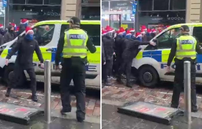 Un tifoso dei Masked Rangers si scontra con la polizia prima di prendere a pugni un furgone mentre un enorme gruppo di ultras marciano verso la partita del Celtic durante la marcia dei SANTA HATS