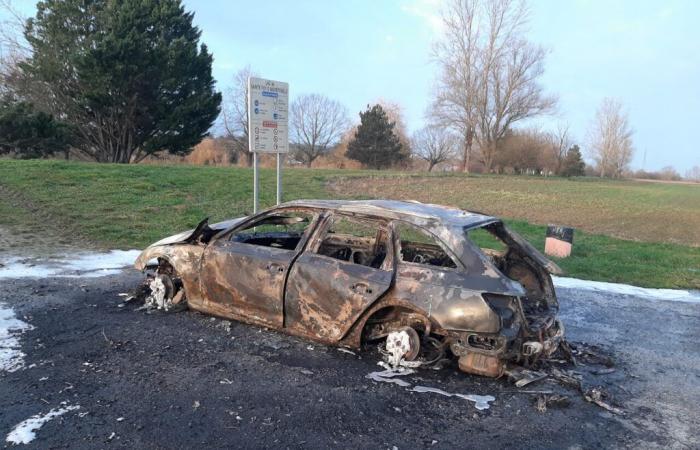 i vigili del fuoco intervengono nel parcheggio di un lago per spegnere un'auto in fiamme