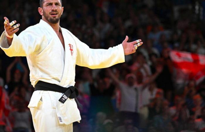 Un cucciolo di leone tenuto da un campione di judo raccolto in uno zoo