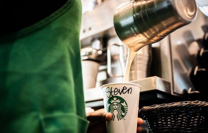 I clienti di Starbucks vedono bar dei condimenti e “per qui” bevande in tazze negli Stati Uniti, in Canada