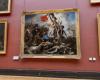 al Louvre, manifesti affissi vicino al dipinto “La Libertà che guida il popolo”